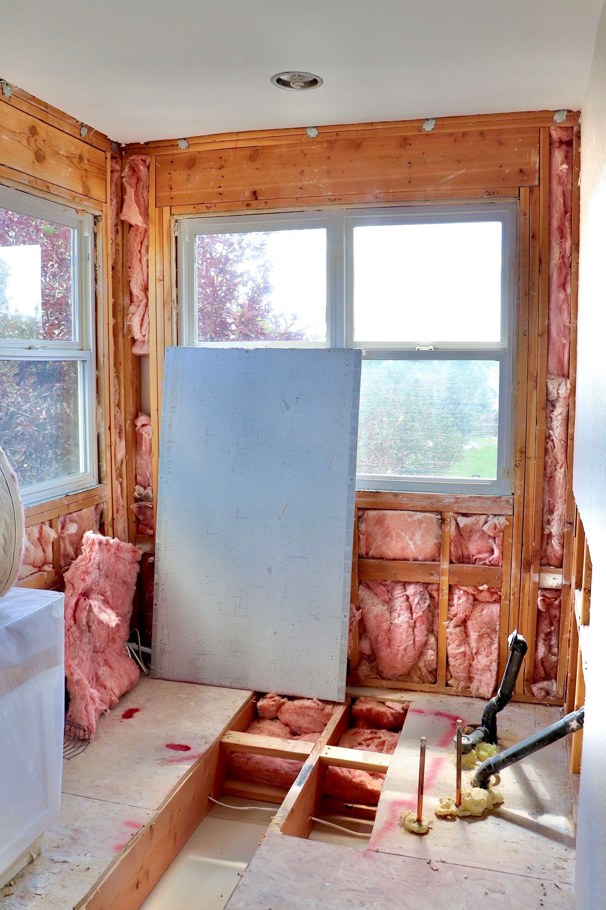Reno project showing exposed wooden framing and plumbing in a bathroom under construction.