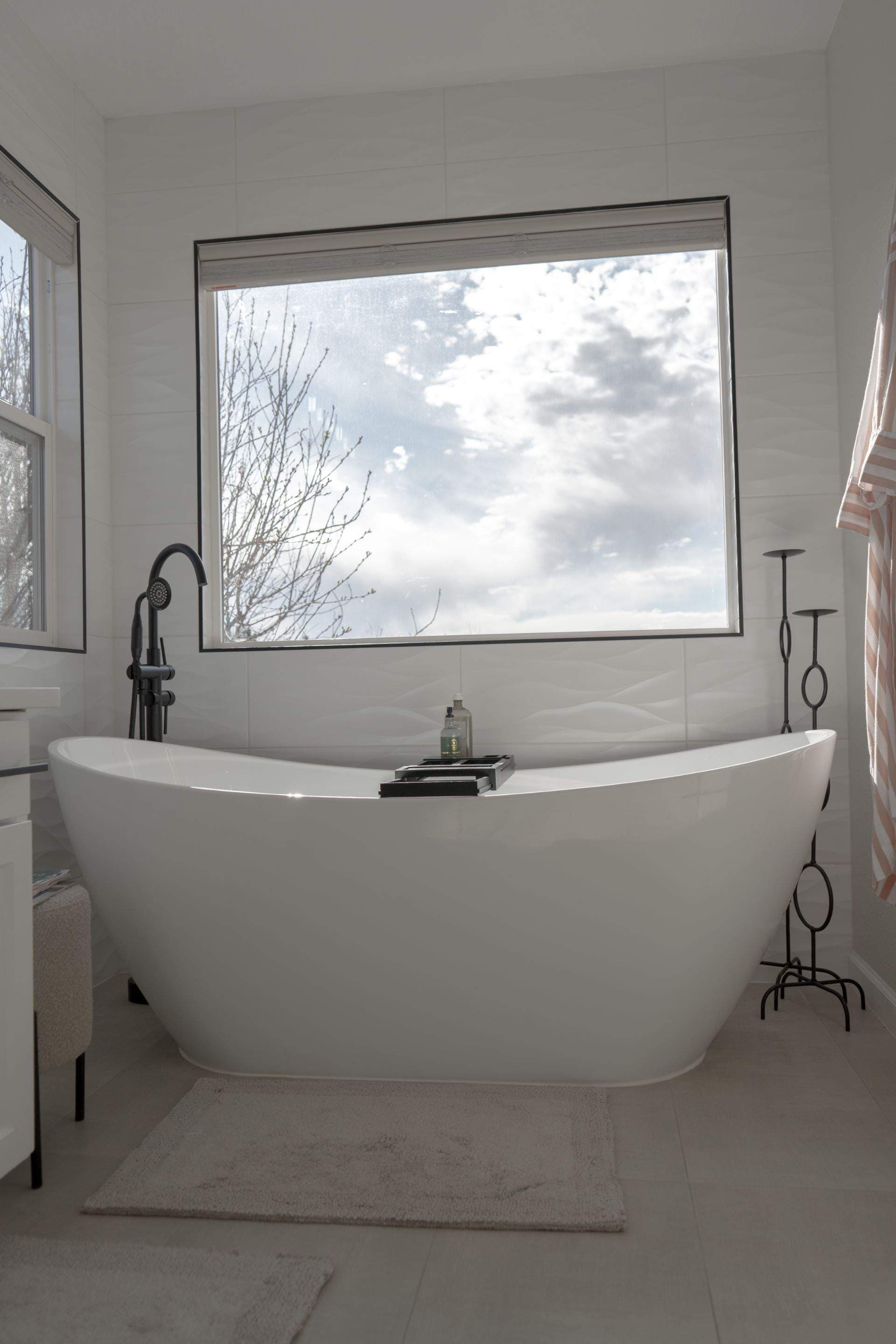 Modern bathroom featuring dual mirrors, stylish lighting, and sleek vanity with storage.