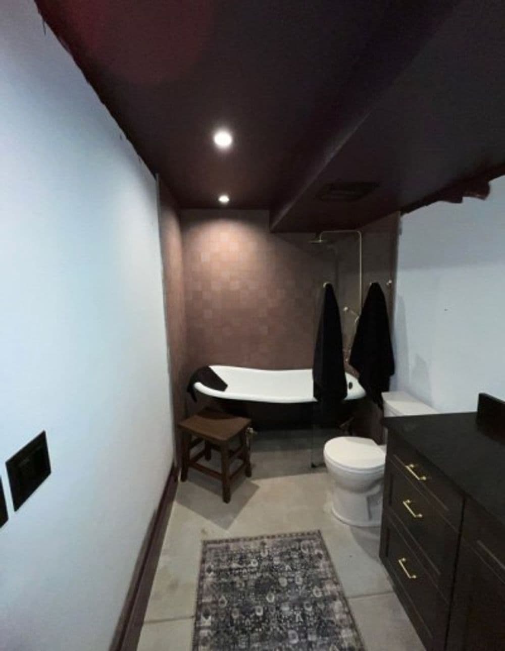 Modern bathroom featuring a freestanding bathtub, dark accents, and sleek fixtures.
