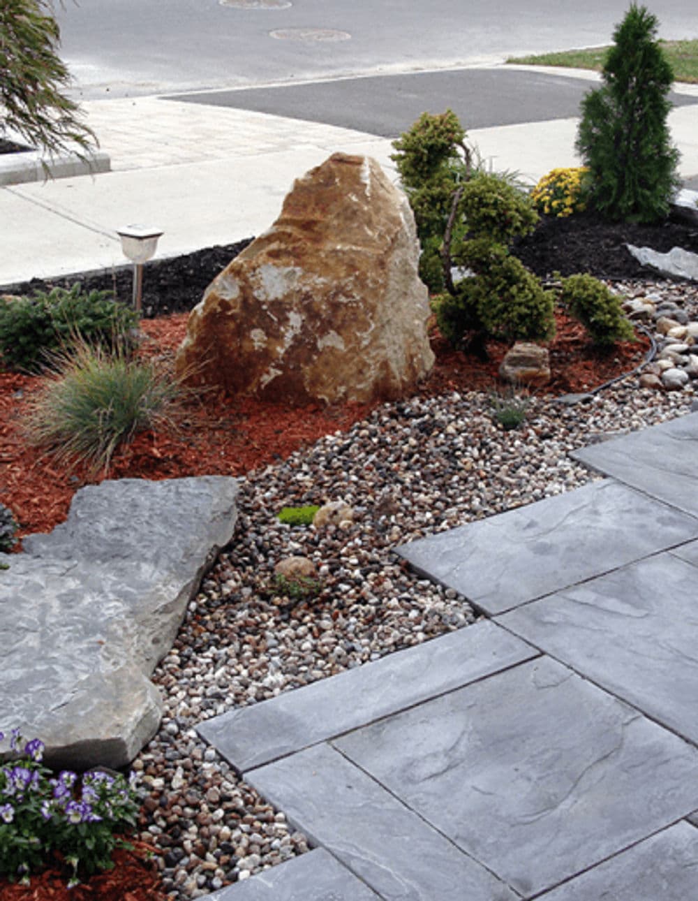 Landscaped garden featuring rocks, shrubs, and gravel pathway for curb appeal.